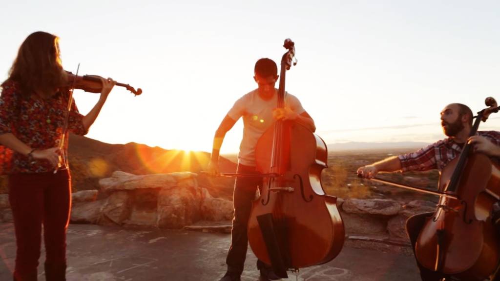 Trois musiciens qui jouent sur un toit