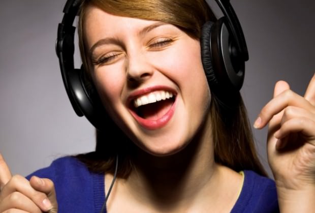 mujer con auriculares cantando y bailando