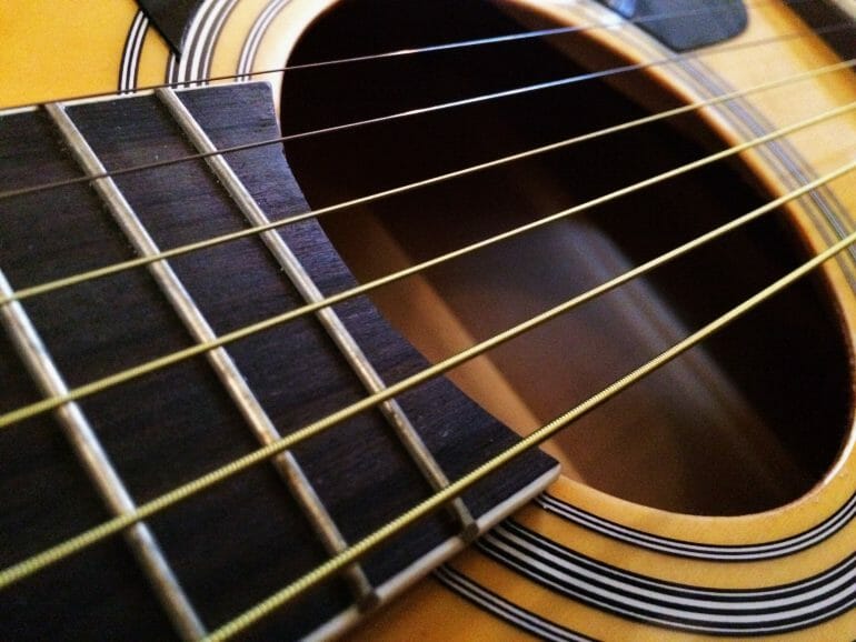 close up of the strings on an acoustic guitar