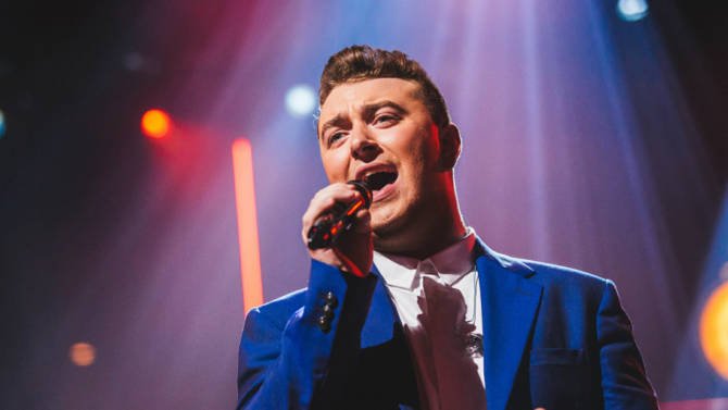 Sam Smith singing with a microphone in his hand